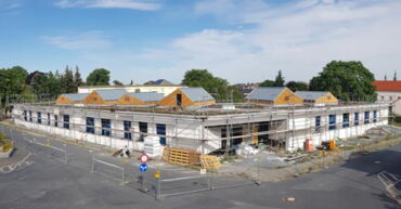 Das Foto zeigt den Neubau der Kita Chladeniusstraße im Rohbau umgeben von Baugerüsten.