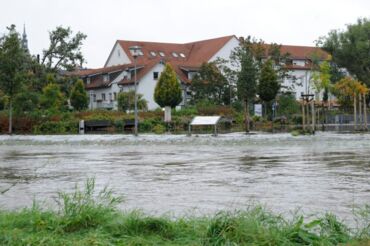 Das Foto zeigt die vom Hochwasser 2010 überspülte Festwiese. Im Hintergrund sieht man die Wohnegbäude an der Carl-Maria-von-Weber-Allee.