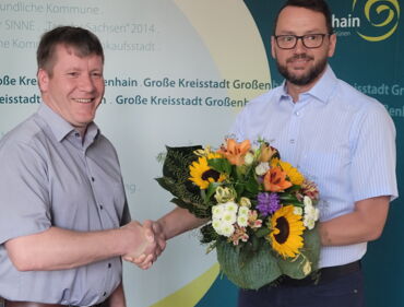 Das Foto zeigt Oberbürgermeister Sven Mißbach (links) und Wahlleiter Silvio Ihle (rechts). Silvio Ihle überreicht dem wiedergewählten OB einen Blumenstrauß.
