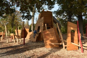 Das Foto zeigt den neugestalteten Spielplatz an der sogenannten Faunhöhe. Man sieht viele Holz-Kletter-Elemente und ein Kind, welches klettert.