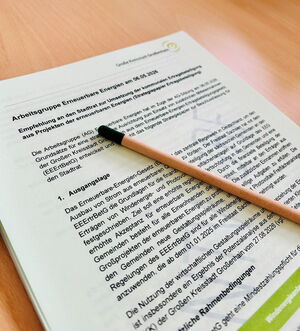 Auf einem Stapel Papier, das eng beschrieben ist, liegt ein schwarzer Stift.