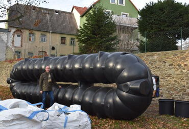 Das Bild zeigt den großen Wassertank, der später in der Carl-Maria-von-Weber-Allee eingegraben wurde. Im Vordergrund sieht man einen Mann als Größenvergleich.