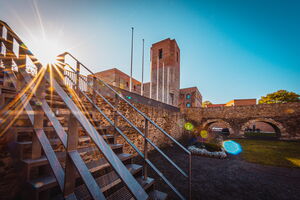Das Foto zeigt eine stimmungsvolle Ansicht des Bergfriedes am Kulturschloss im Abendsonnenschein.