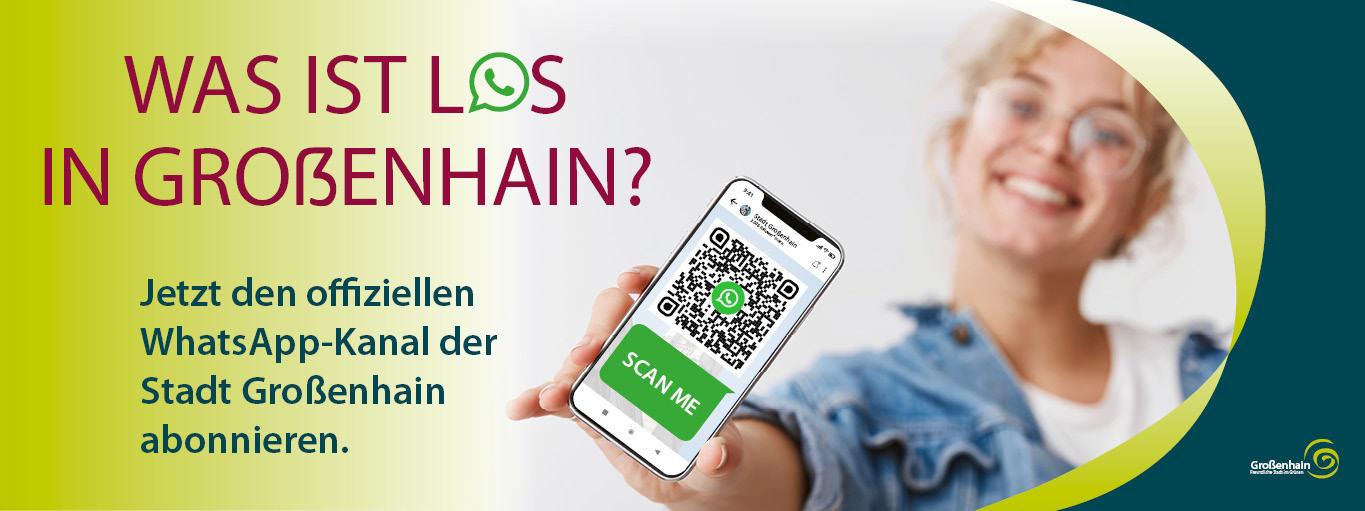 Eine junge Frau mit Brille und blonden Locken streckt dem Betrachter ein Handy mit einem QR-Code entgegen. Auf dem Banner links daneben steht: Was ist los in Großenhain. Jetzt den offiziellen WhatsApp-Kanal der Stadt Großenhain abonnieren.